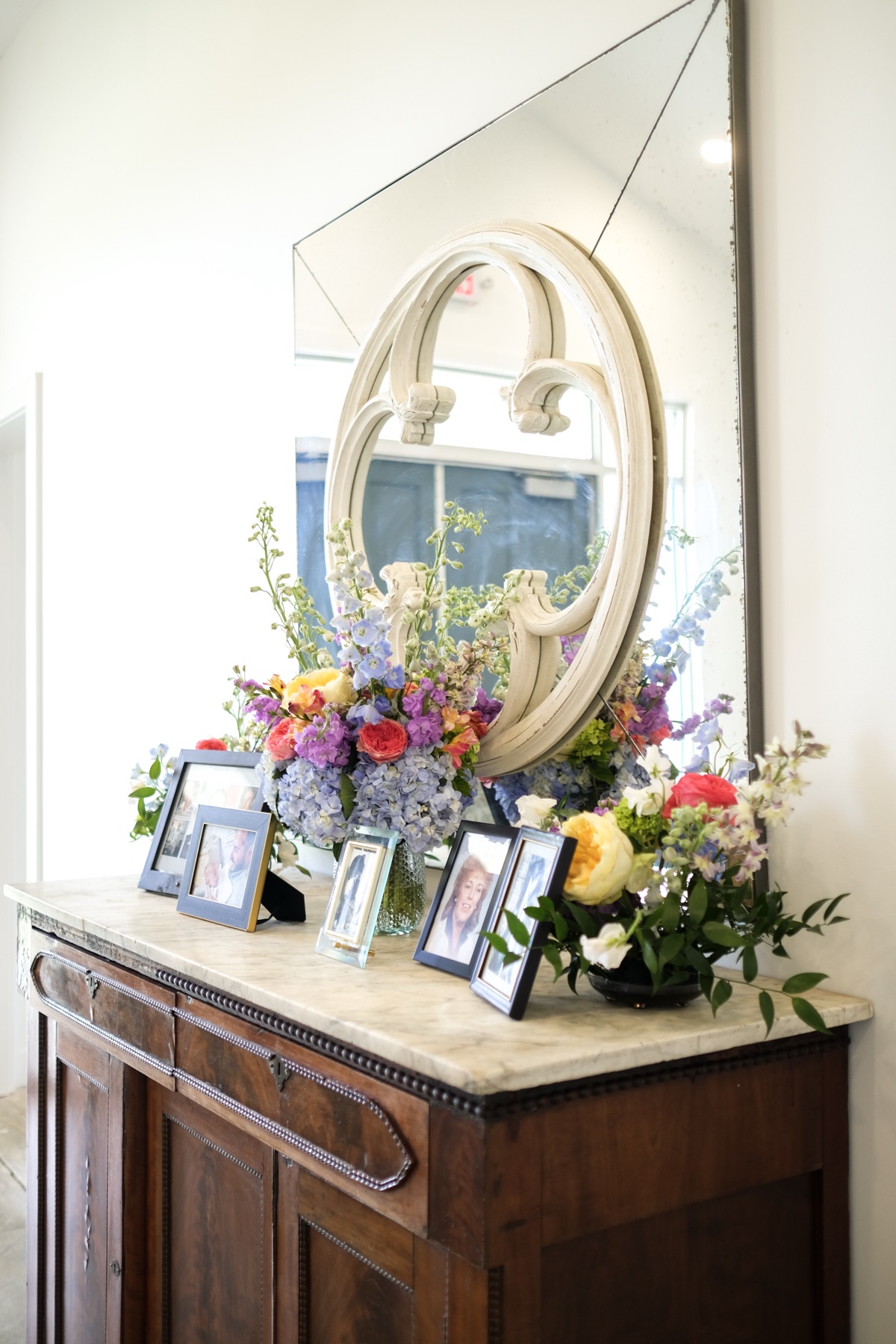 Floral arrangement on a dresser with photo frames