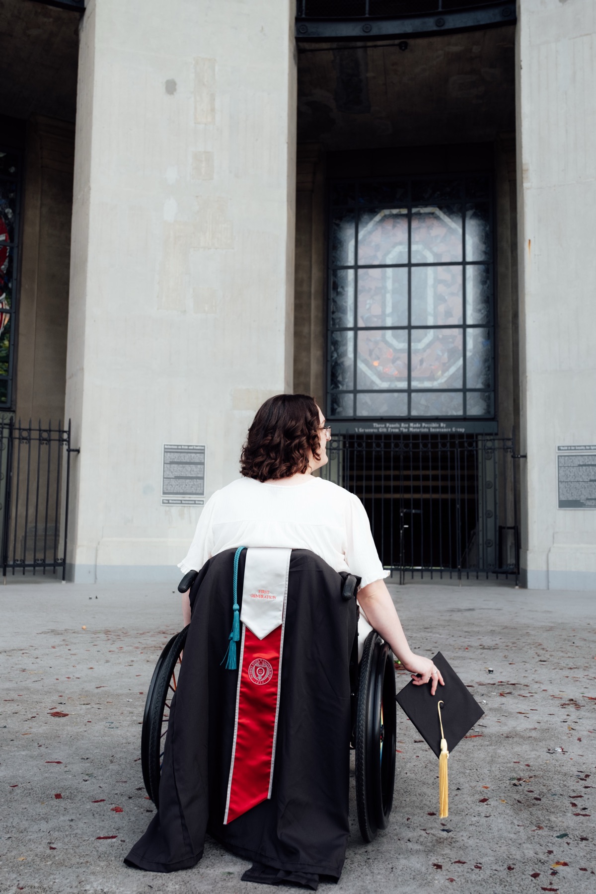 Graduate standing before tall architectural columns
