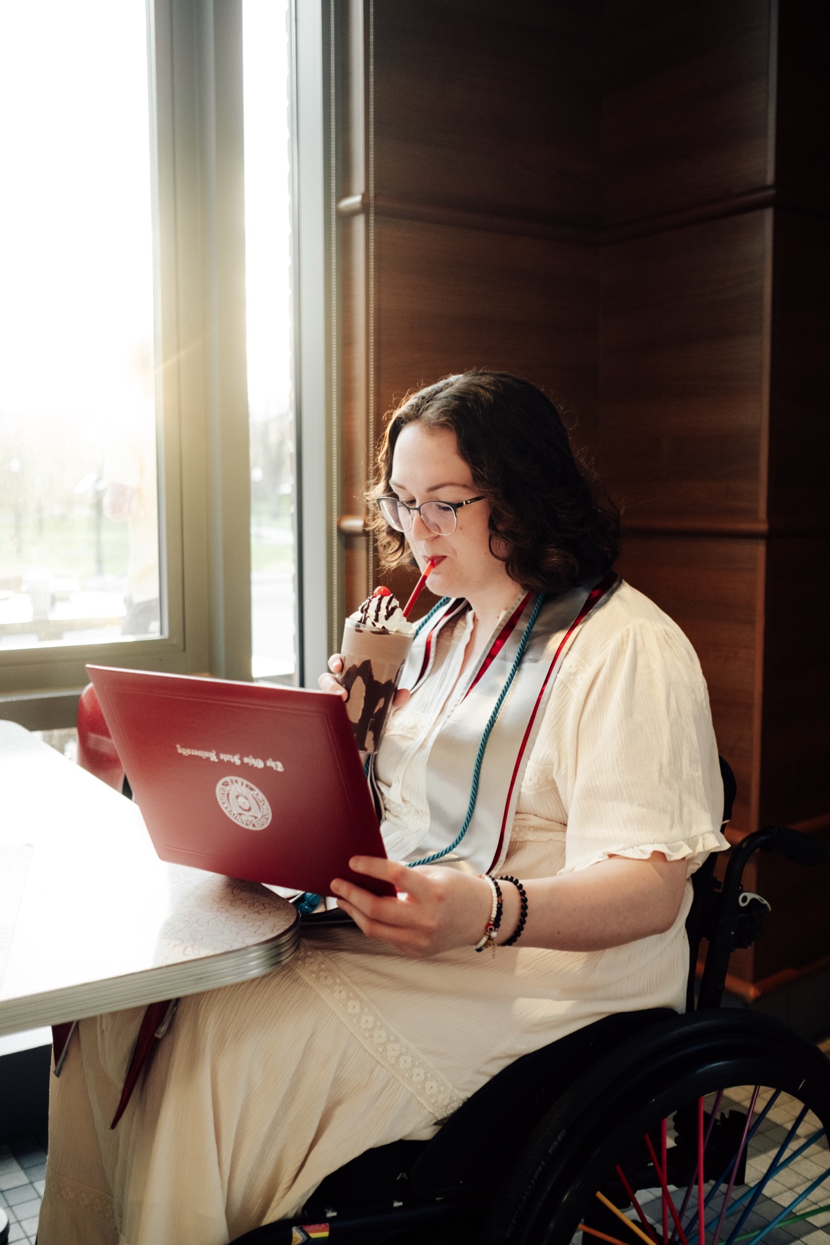 Graduate working on a laptop at a cafe