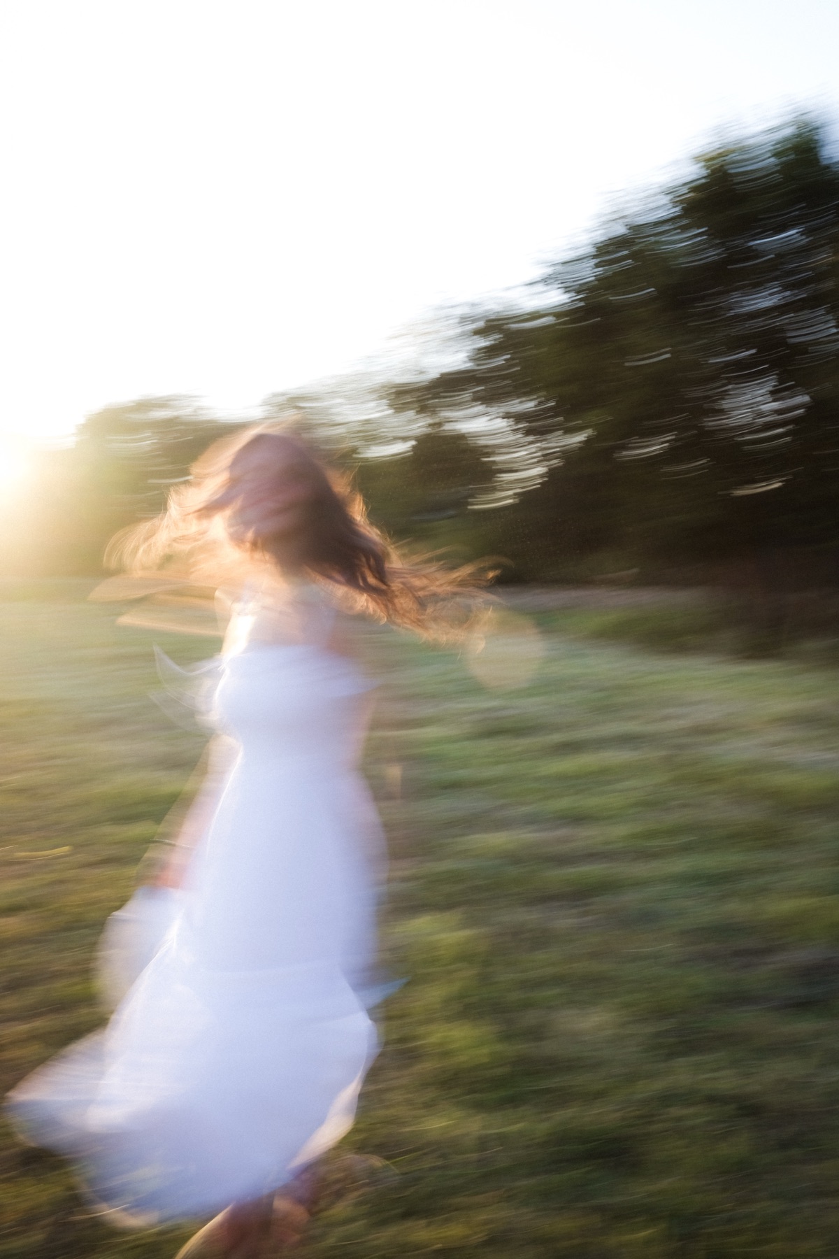 Senior portrait in motion, running through a field