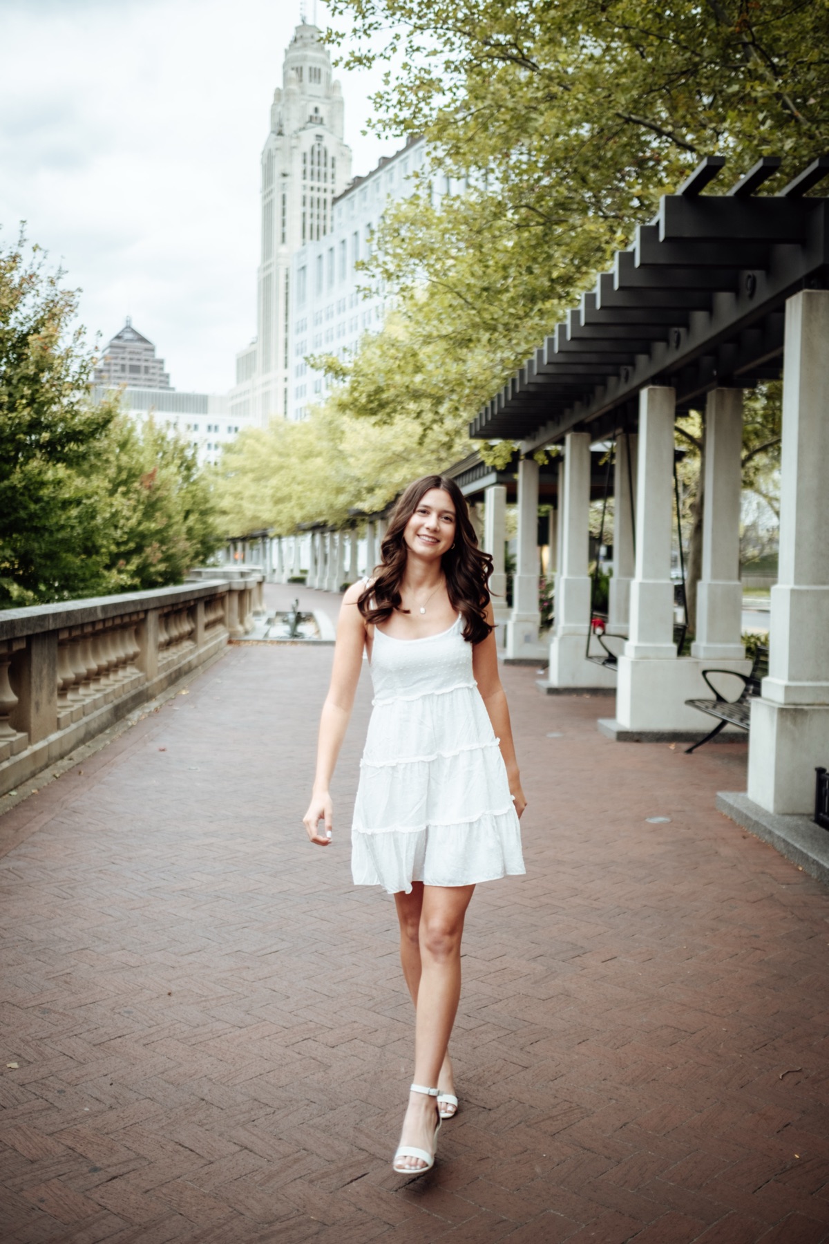 Senior portrait walking along a brick walkway