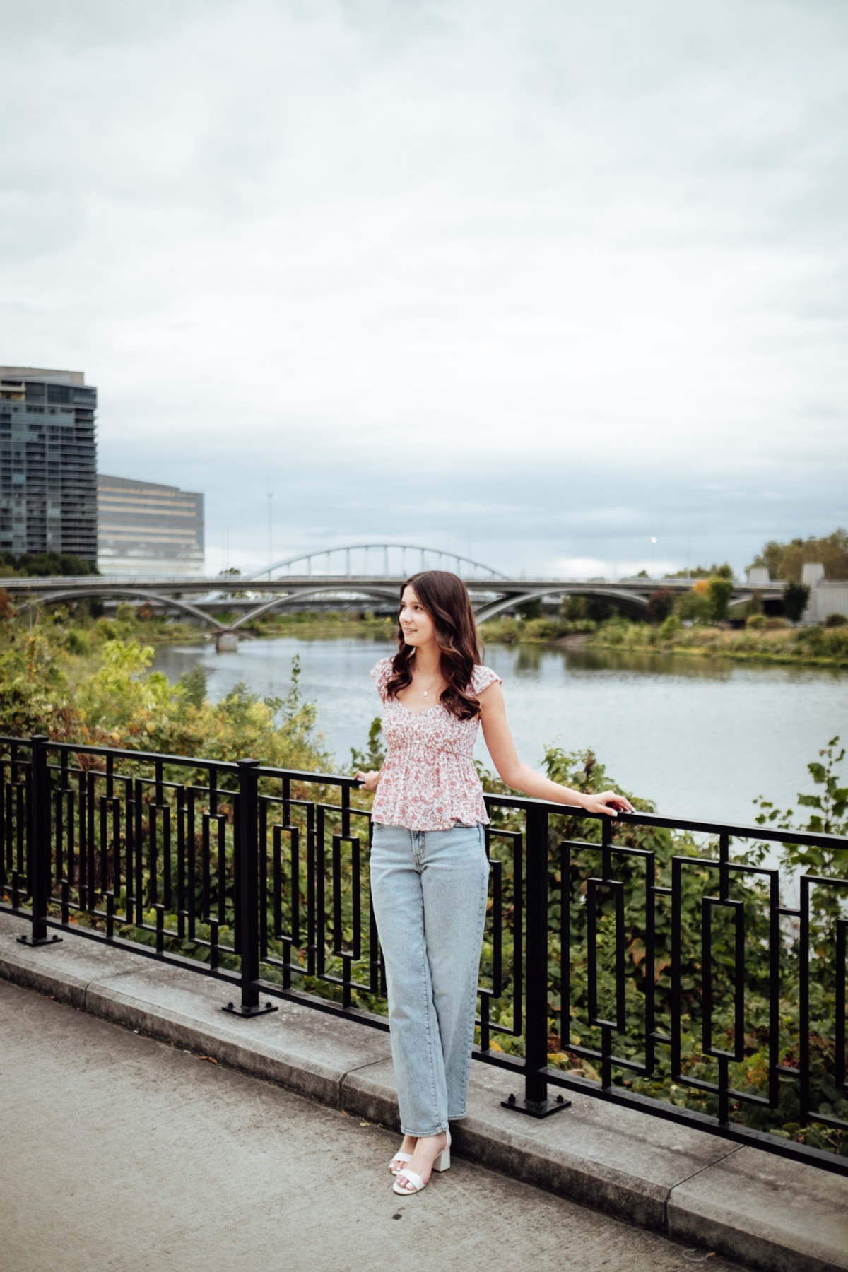 Senior portrait leaning on a railing by the water