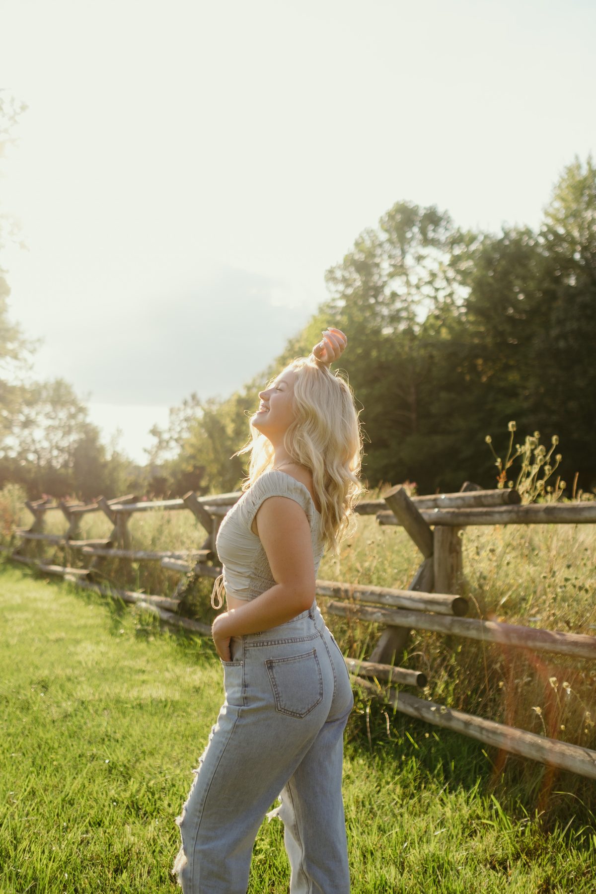 Senior portrait laughing in a sunlit field