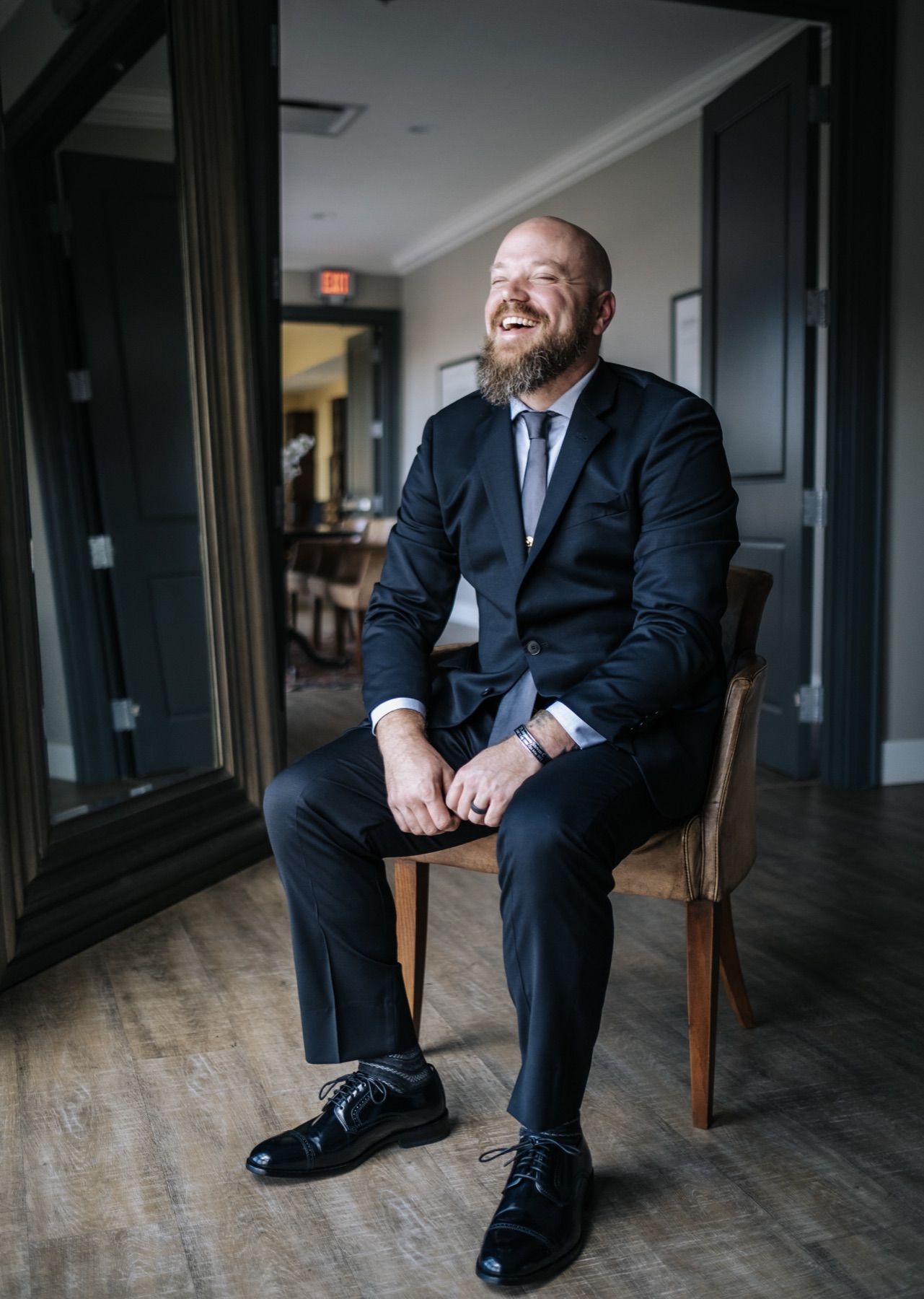 Groom laughing, seated indoors